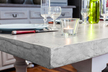 Detailed texture of thick kitchen table covered in waxed concrete, with ready table set, Airbnb style decoration, retro style renovation of old countryside house, seasonal rental, Provence, France