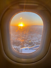 Watching the sunrise from a scheduled plane window.