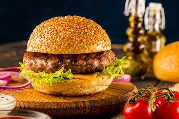 Grilled gourmet burger with cheese, tomato, and homemade sesame bun