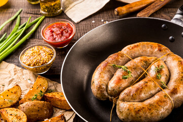 grilled sausages. spices and herbs on black background close up. Roasted homemade wurst sausages