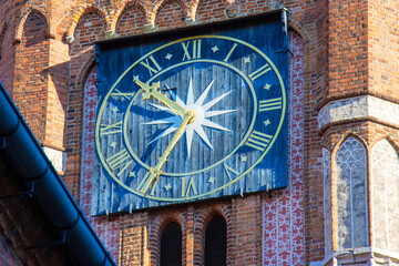Closeup of a clock on a town hall tower, Torun, Poland.