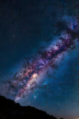 Obraz premium Milky Way galaxy across a clear night sky, vibrant stars with a mix of blue and purple tones