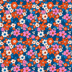 Beautiful floral pattern in small flowers. Small bright red, pink and white flowers. Dark blue background. Liberty print. Floral seamless background. Elegant template for fashion prints. Stock pattern