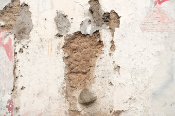 Awhite walled building that looks damaged