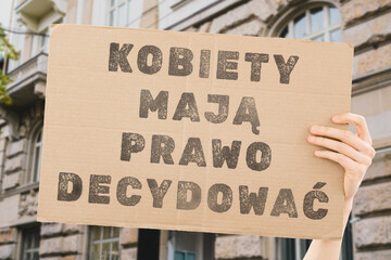 The phrase 'Women have the right to decide' on a banner in a person's hand. Human holds a cardboard...