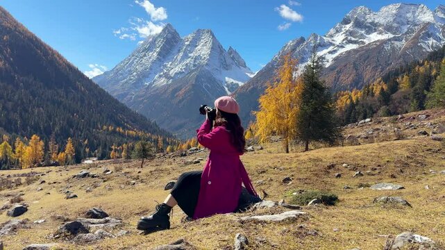Tourist taking photo of Siguniangshan in autumn, Sichuan in China.