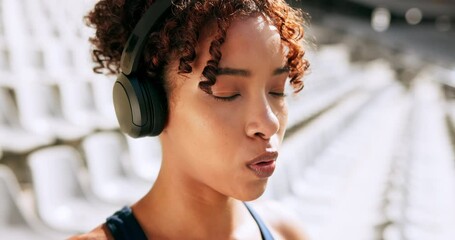 Woman, runner or breathing with headphones at stadium for race, sprint or workout preparation. Young, female person or serious athlete with music for stretching, exercise or getting ready for fitness