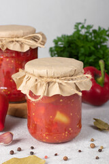Pickled sweet peppers with tomatoes in two glass jars