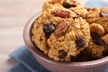 Delicious oatmeal cookies with raisins and nuts on table, closeup