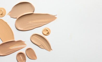Samples of foundations on white background, top view