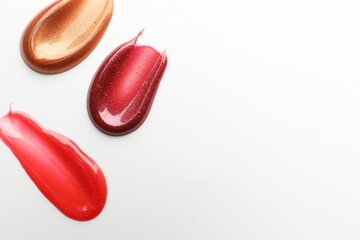 Smears of different lip products on white background, top view