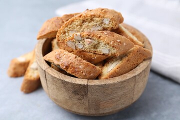 Traditional Italian almond biscuits (Cantucci) in bowl on grey table, closeup
