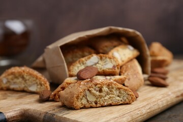 Tasty almond biscuits (Cantuccini) and nuts on wooden table, closeup