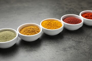 Different aromatic spices on grey table, closeup