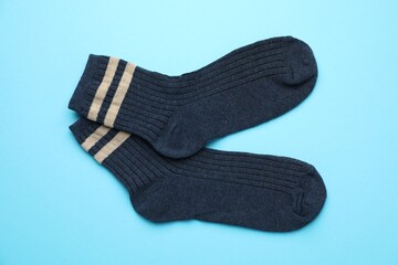 Pair of soft comfortable socks on light blue background, top view