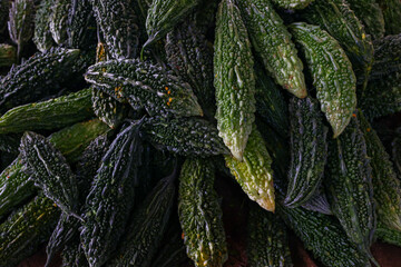lots of green fresh bitter gourd karela for sale in vegetable market