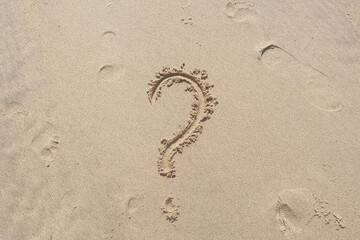 Question word on yellow sand background on the beach.