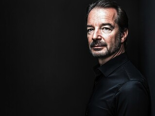 Obraz premium Serious man with beard looking at camera against dark background