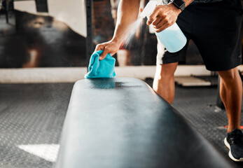 Person, hands and spray with sanitizer at gym for hygiene, bacteria or germ removal on bench or...