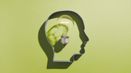 A creative concept featuring a light bulb shaped like a human head silhouette, symbolizing innovation and ideas on a vibrant green background.
