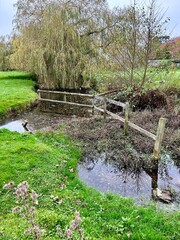 Fototapeta premium Rural English countryside background showing a steam and trees 