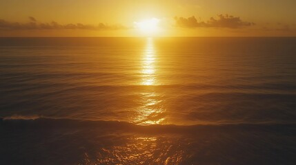 A tranquil sunset over the ocean, casting a golden glow on the water and reflecting serene hues in the sky.
