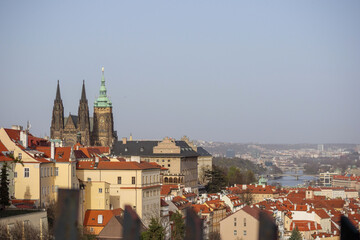 Obraz premium view of the old town church and buildings with red tiled roofs against a blue sky background