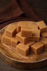 Tasty sweet caramel candies on wooden table, closeup