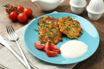 Delicious potato pancakes served on wooden table, closeup