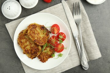 Delicious potato pancakes served on grey table, flat lay