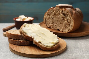 Fresh bread with butter on grey table, closeup