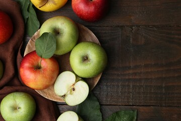 Different ripe apples on wooden table, flat lay. Space for text