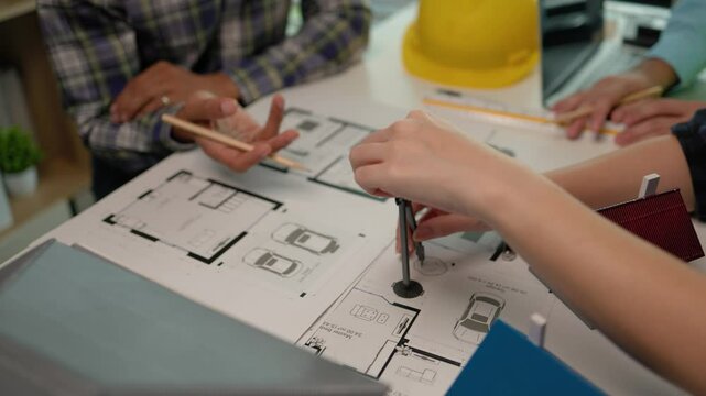 A group of structural engineers and contractors are meeting to discuss a structural design that meets international safety standards, The architects are discussing model homes and blueprints.