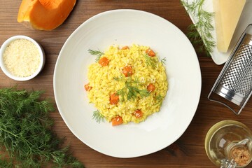 Delicious pumpkin risotto on wooden table, flat lay