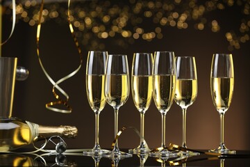 Champagne in glasses and bottle on mirror surface against brown background with blurred lights
