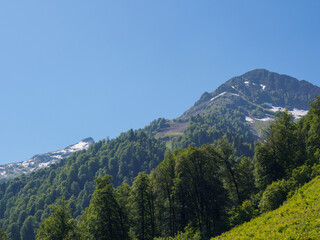 Epic mountain ranges twisting under the sun, with vibrant slopes and cloud shadows, embody the...
