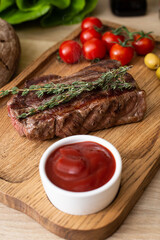 Hot steak with rosemary on a wooden board.
