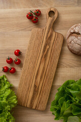 A light cutting board lies on the kitchen table, top view.