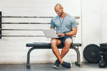  Laptop, typing and manager with man in gym for fitness instructor, planning and digital membership record. Online schedule, personal trainer and equipment supervisor with person in health facility © peopleimages.com