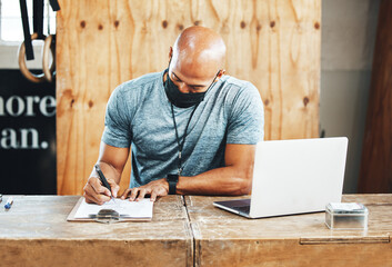 Face mask, man and writing at gym with laptop, clipboard and personal trainer with onboarding and...
