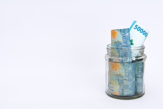 some bills rupiah in a clear jar