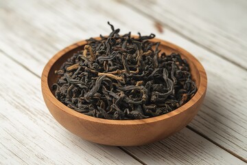 Fototapeta premium a wooden bowl filled with black, dried tea leaves