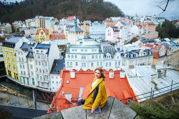 A beautiful girl sitting against the background of Karlovy Vary and enjoys the journey. 