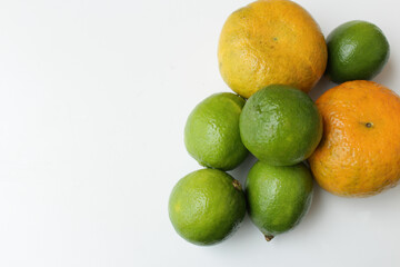 Organic oranges and limes on white background for vegan diet. Brazilian tropical fruits. Antioxidants and vitamins for healthy vegetarian meal.