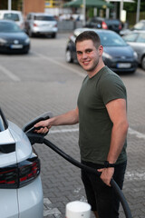 Man Charging Electric Car in Parking Lot