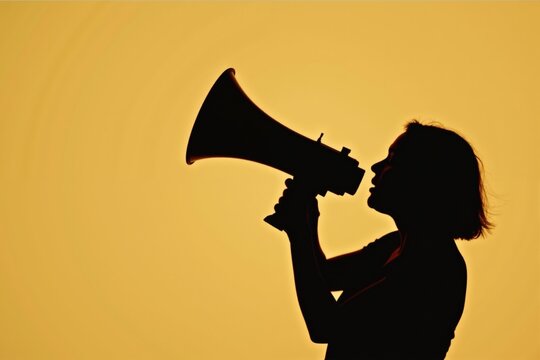 Silhouette of a woman shouting into megaphone against bright yellow background. - Powered by Adobe