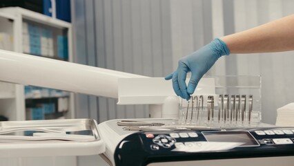 Close-up dentist's hand takes an orthodontic archwire for braces