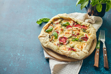 Galette-type pie made from puff pastry and filled with tomatoes, mozzarella cheese and pesto sauce. Galette Caprese