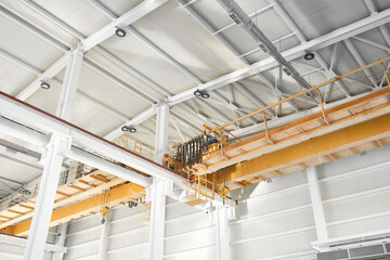 Bridge cranes inside hangar. Overhead cranes inside industrial building