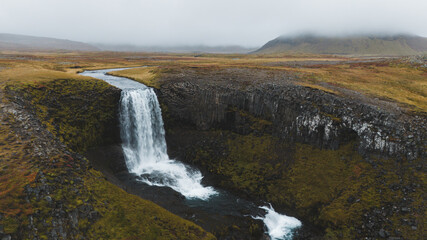 Long waterfall with a rough cliff
